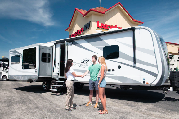 Couple selling their RV to an RV dealership standing outside of the RV.