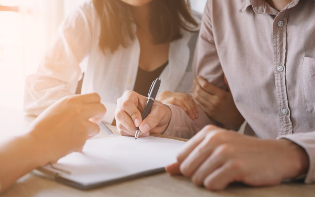 Close up of couple signing RV selling paperwork